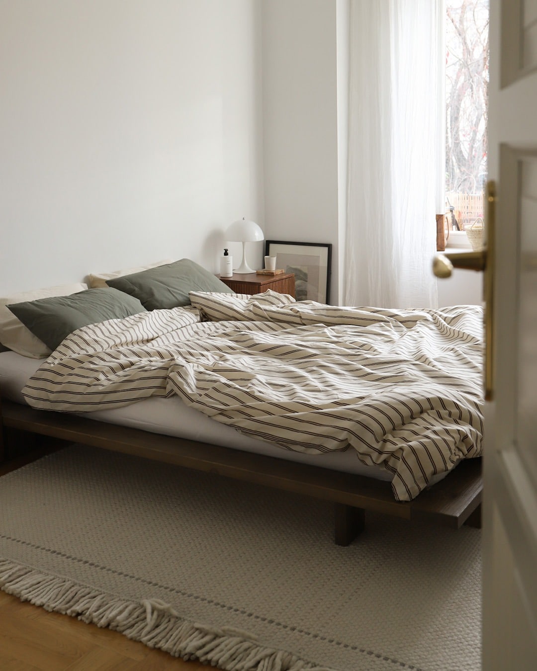 19. Minimal White Bedroom with Low Wood Platform Bed and Neutral Textiles - white wall bedroom ideas