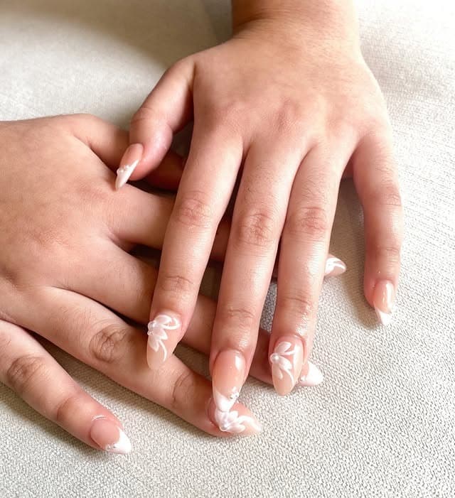 5. Sheer Nude Almond Nails with White Floral Tips - minimalistic nail ideas