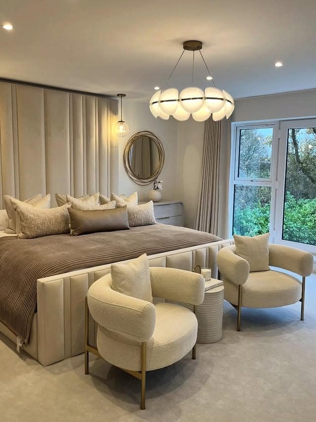 15. Warm Neutral Bedroom with Round Mirror Accent and Layered Seating - bedroom ideas with mirror