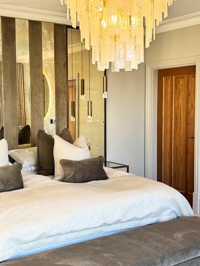 18. Glam Bedroom with Mirrored Panels and Statement Chandelier - bedroom ideas with mirror