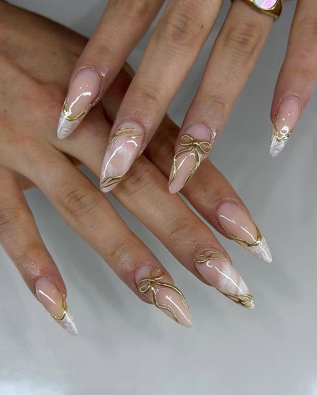 21. Nude Stiletto Nails with White Marble Tips and Gold Bow Accents - nail ideas with gold