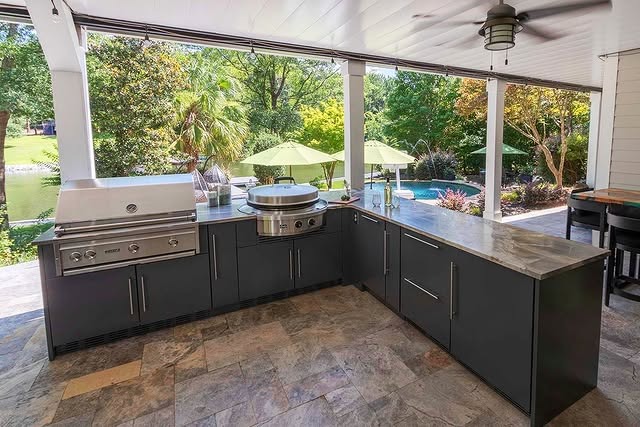 3. Classic Covered Patio Kitchen with Deep Charcoal Cabinets and Stone Flooring - outdoor kitchen ideas