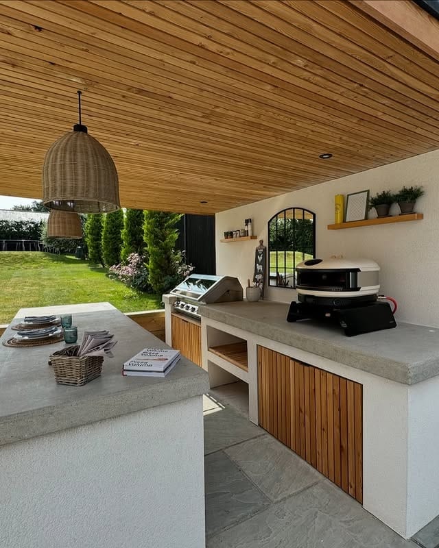18. Minimalist Outdoor Kitchen with Light Concrete and Wood Accents - outdoor kitchen ideas