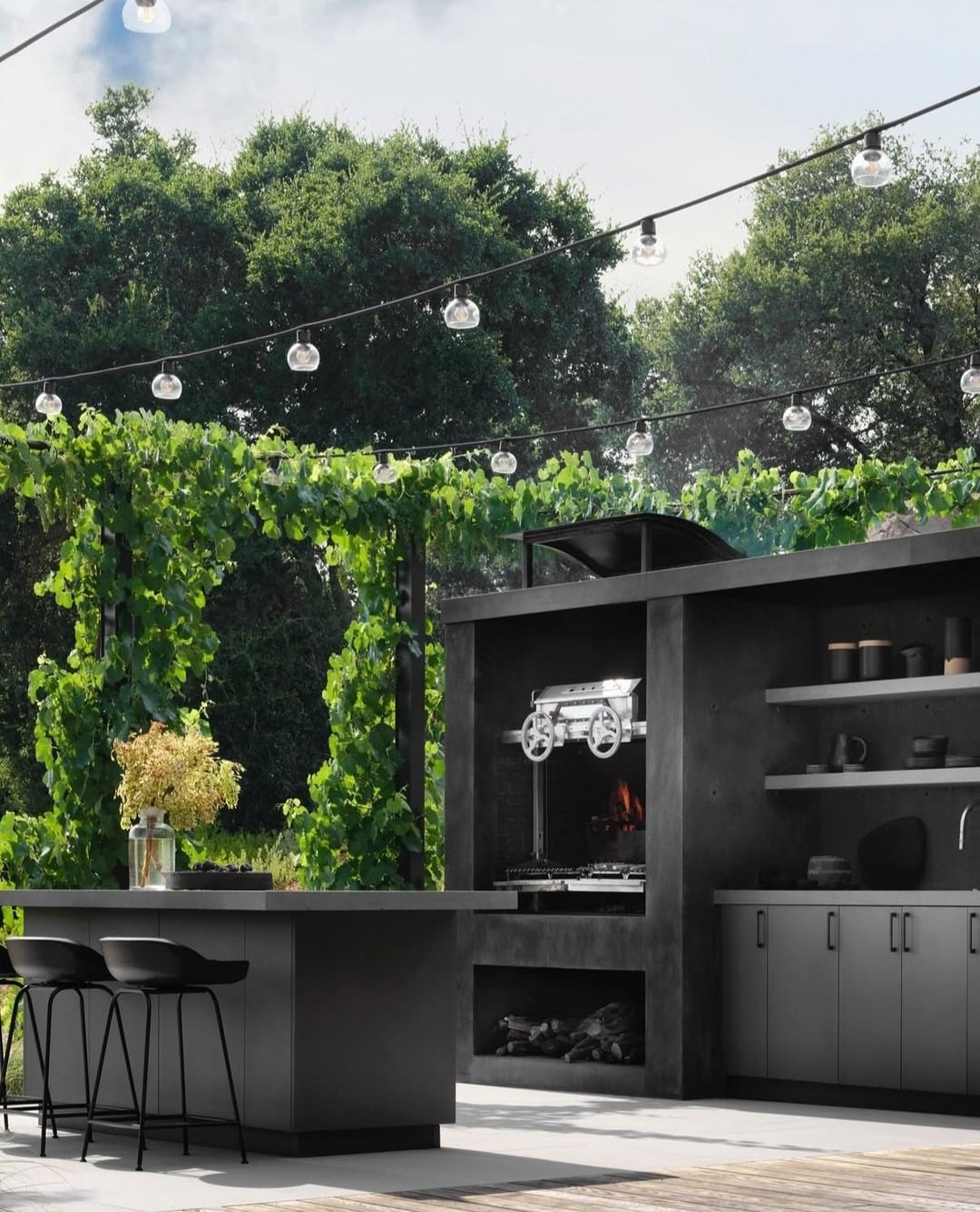 22. Contemporary Outdoor Kitchen with Charcoal Finishes and Lush Green Surroundings - outdoor kitchen ideas