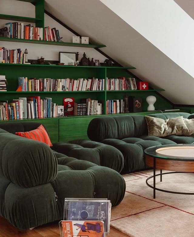 5. Moody Green Library Lounge with Sculptural Seating - green living room ideas