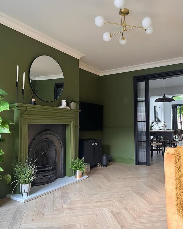 9. Deep Green Fireplace Wall with Modern Brass Lighting - green living room ideas