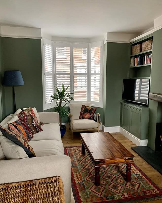 12. Muted Green Bay Window Living Room with Classic Comfort - green living room ideas