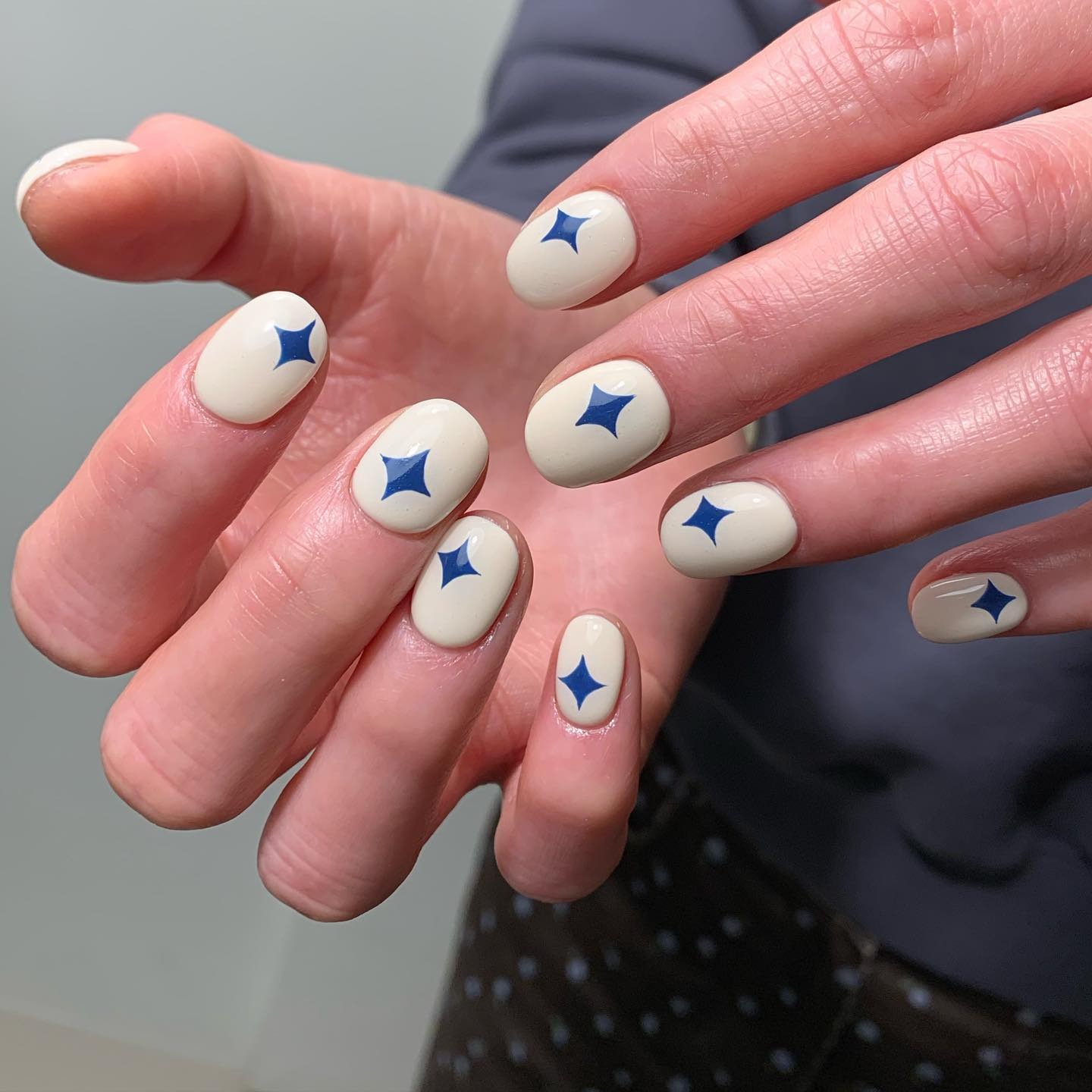 14. Cream Base with Blue Star Accents - easy nail ideas