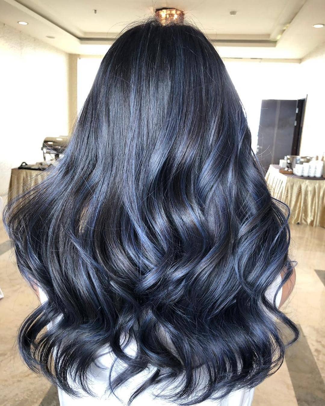 3. Glossy Blue-Black Voluminous Curls - Smoky Blue Hair Color