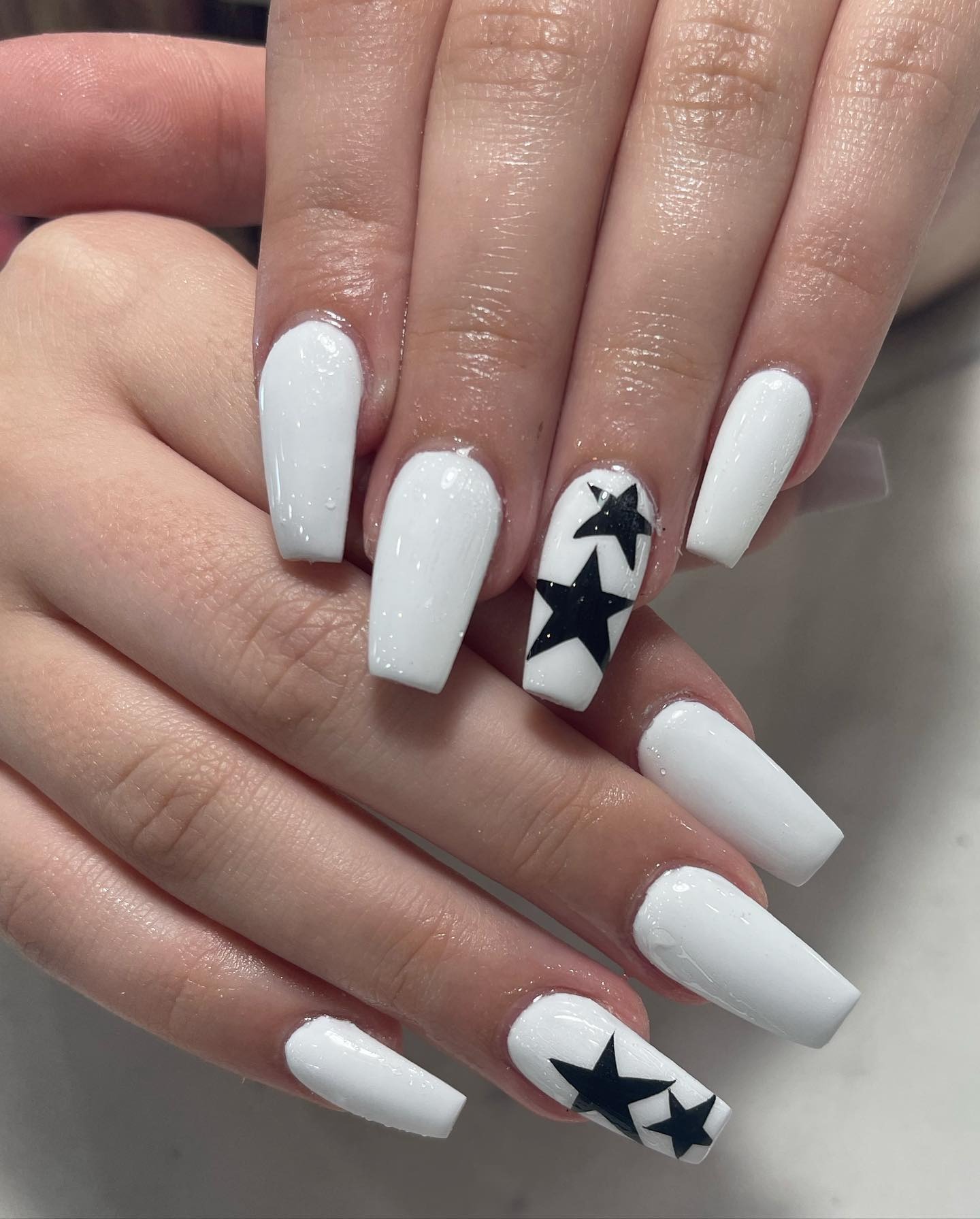 14. Glossy White Coffin Nails with Black Star Art - homecoming nail ideas