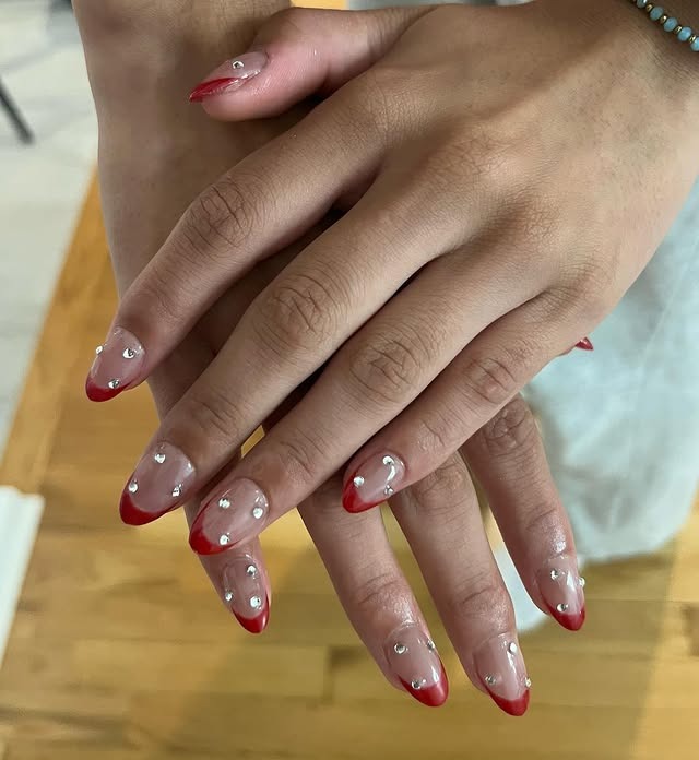20. Red French Tip Almond Nails with Rhinestone Accents - homecoming nail ideas