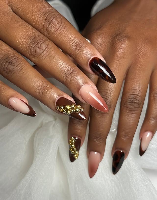 4. Glossy Brown Almond Nails with Gold Embellishments - fall nail ideas