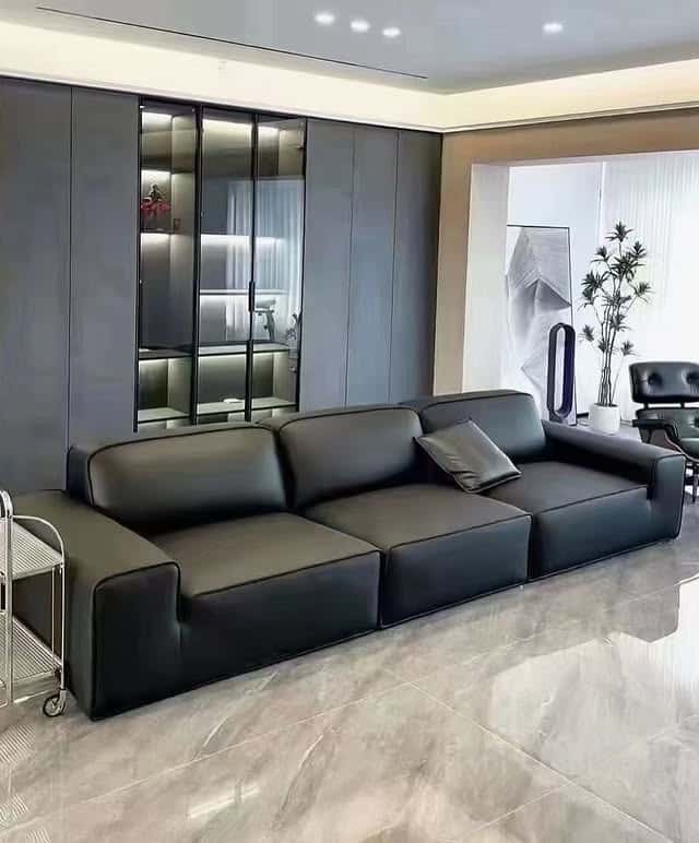 14. Minimal Black Leather Sofa with Sleek Storage Wall - black sofa living room ideas