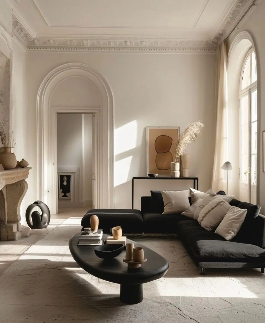 21. Minimal Black Sofa in Soft Neutral Architectural Space - black sofa living room ideas