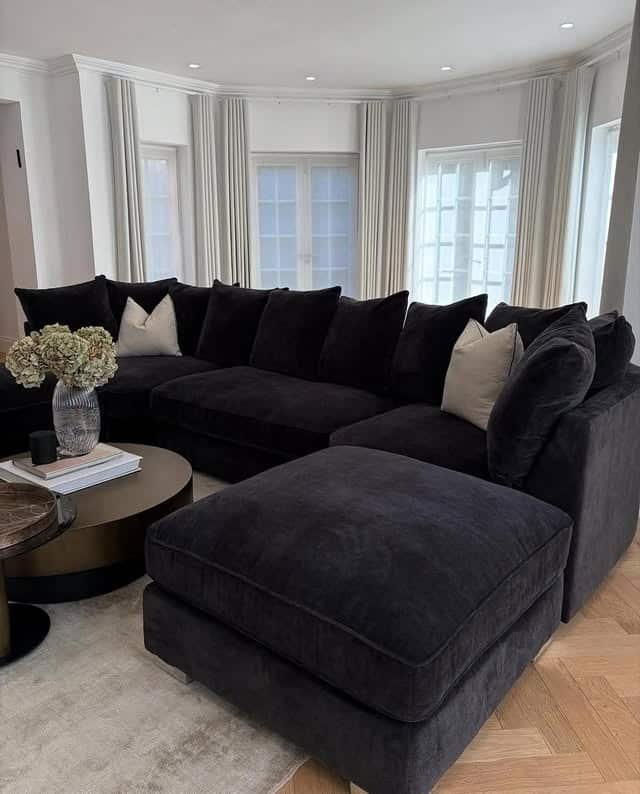22. Plush Black Sectional with Light-Filled Bay Windows - black sofa living room ideas