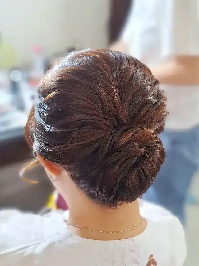 21. Auburn Brown Sleek Low Twisted Bun - Medium Length Hair Messy Updos