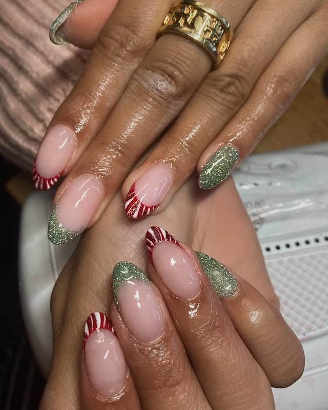 6. Nude Base with Candy Cane and Green Glitter Tips - christmas dip nail ideas