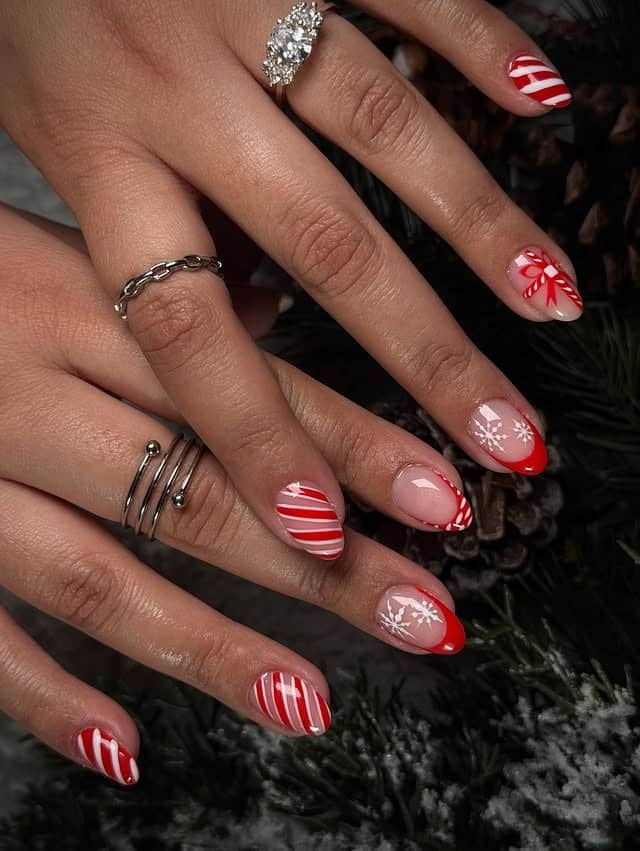 11. Red and White Candy Cane Almond Nails with Snowflake Accents - christmas dip nail ideas