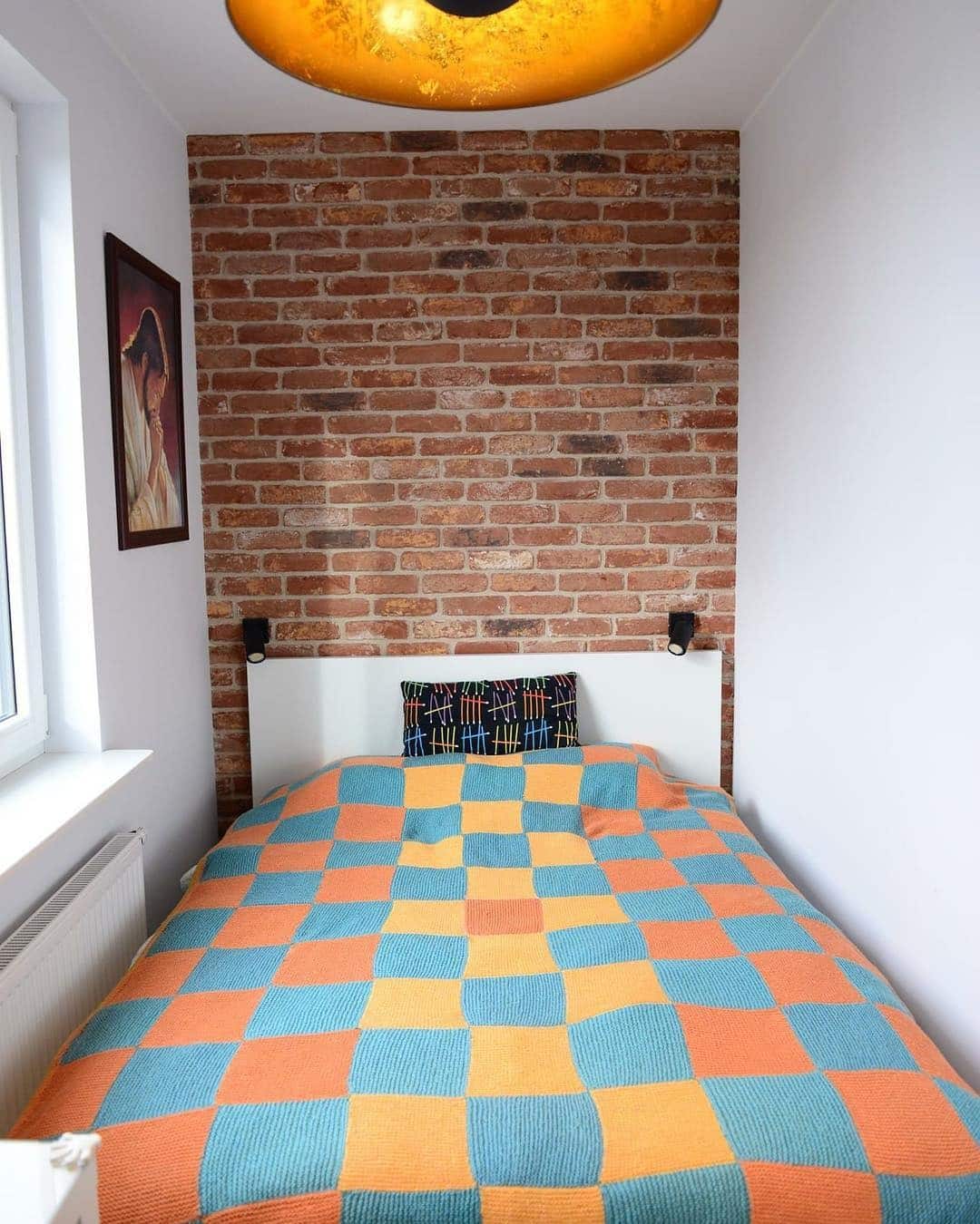 16. Compact Bedroom with Brick Wall and Bold Pattern Bedding - tiny bedroom ideas