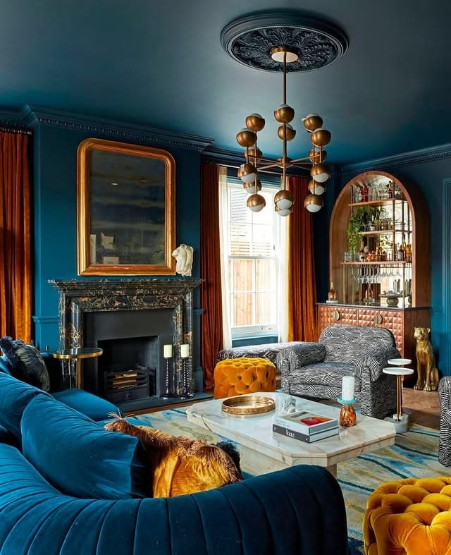 3. Jewel-Toned Blue Living Room with Gold Statement Lighting - blue living room ideas
