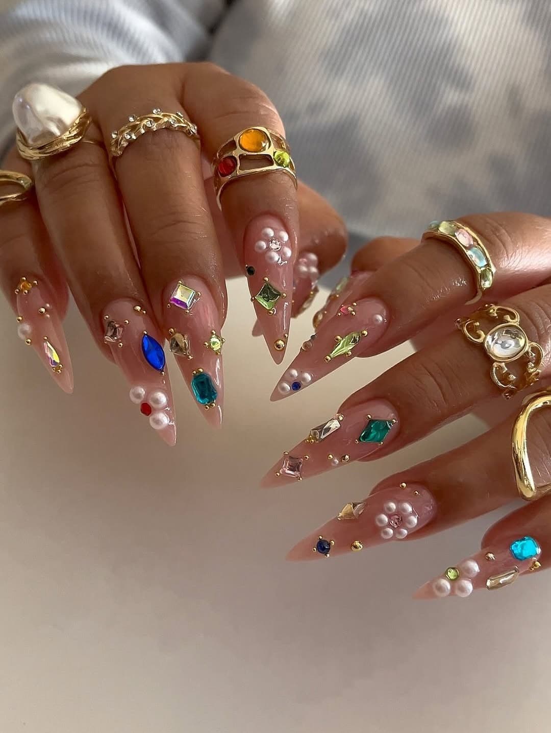 22. Sheer Nude Stiletto Nails with Multicolor Gems and Pearl Accents - nail ideas with gems