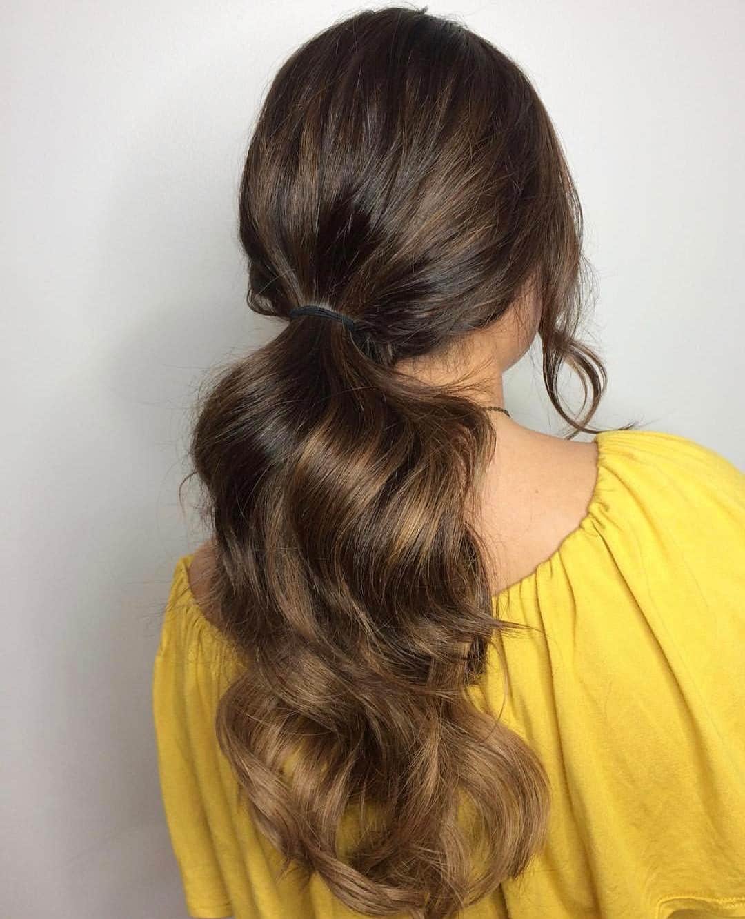 18. Warm Brunette Wavy Layered Ponytail - Layered Ponytail Hairstyles