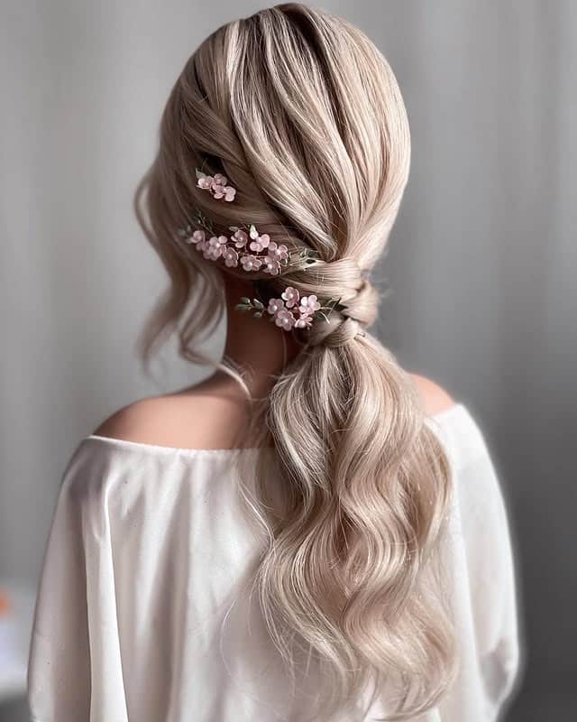 20. Platinum Blonde Twisted Layered Ponytail with Floral Accents - Layered Ponytail Hairstyles