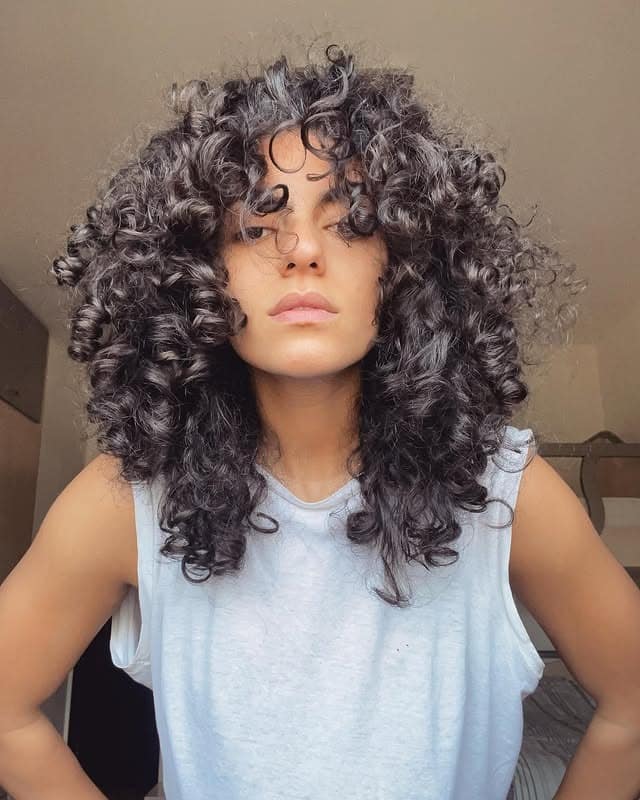 22. Voluminous Dark Brunette Curly Shag - Messy Curly Hair