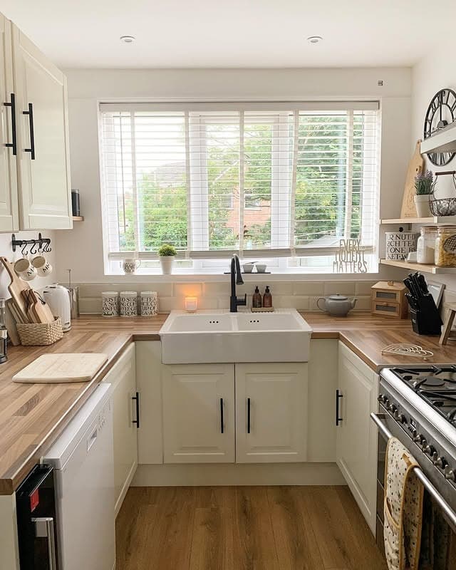 2. Bright Farmhouse Kitchen with Neutral Tones and Black Fixtures - country style kitchen ideas