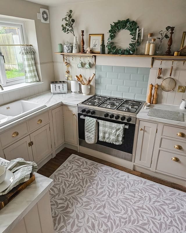 9. Soft Green Country Kitchen with Open Shelving and Brass Details - country style kitchen ideas