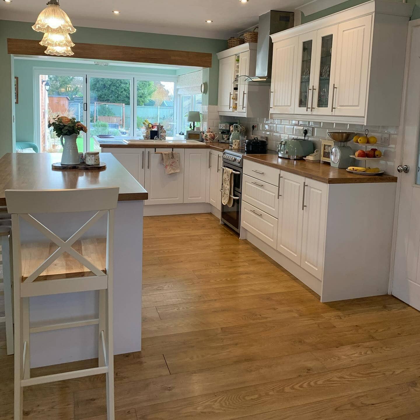 17. Bright Country Kitchen with Sage Walls and Classic White Cabinetry - country style kitchen ideas