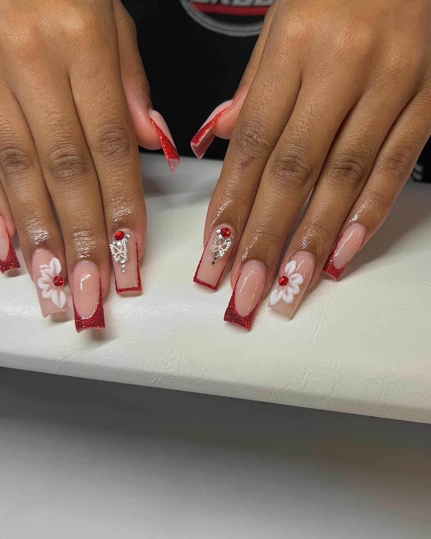 10. Red Glitter French Tip Nails with Floral and Crystal Details - red prom nail ideas