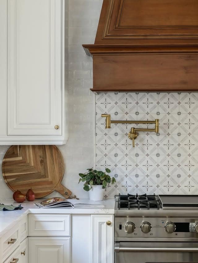 22. Soft White Pattern Tile with Warm Wood Range Hood - kitchen tile ideas