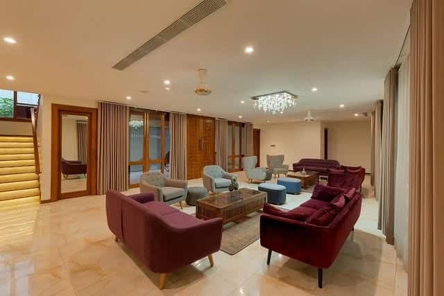 16. Spacious Living Room with Deep Burgundy and Neutral Base - large living room ideas