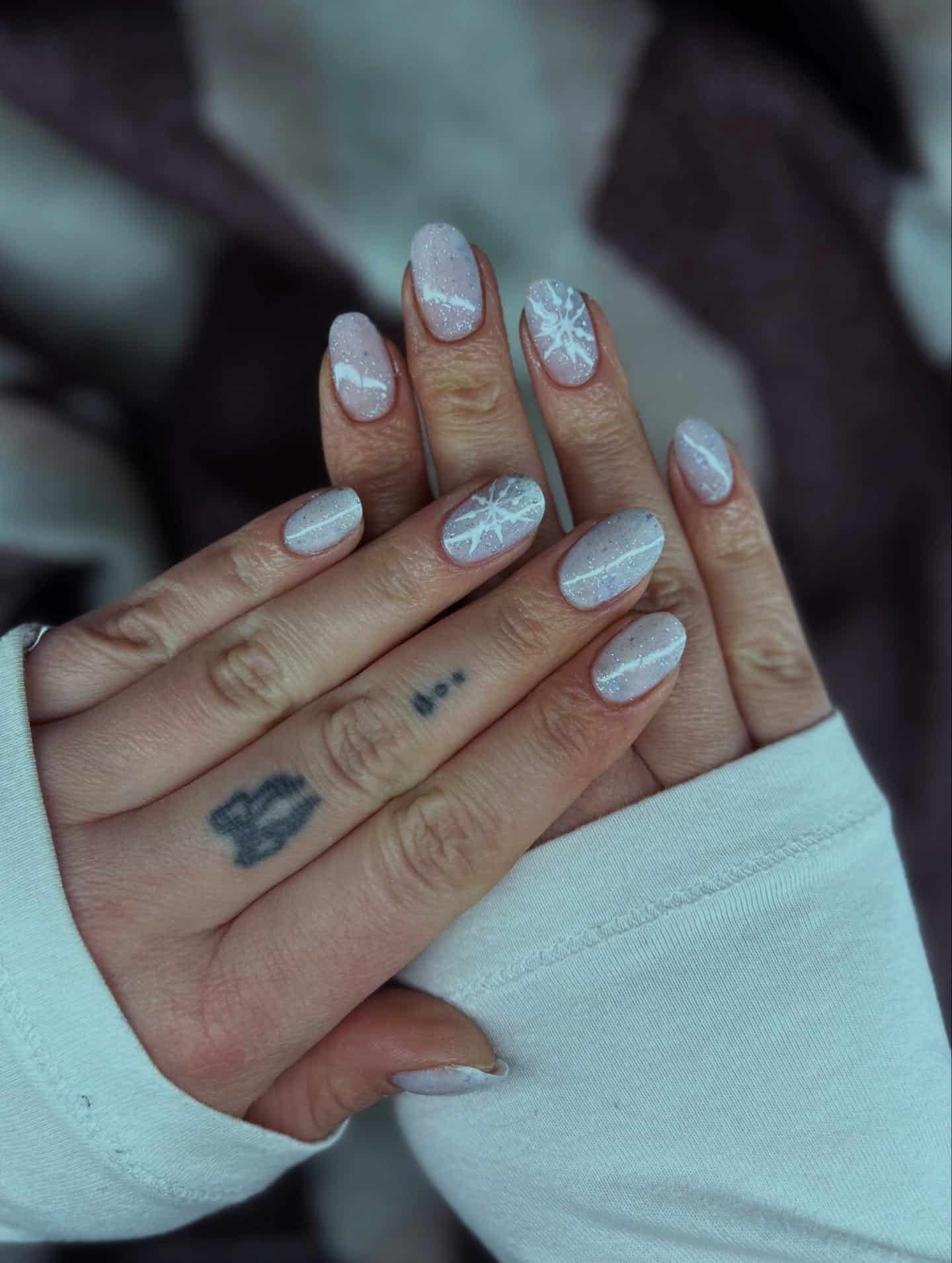 9. Frosted White Glitter Nails with Snowflake Details - short winter nail ideas