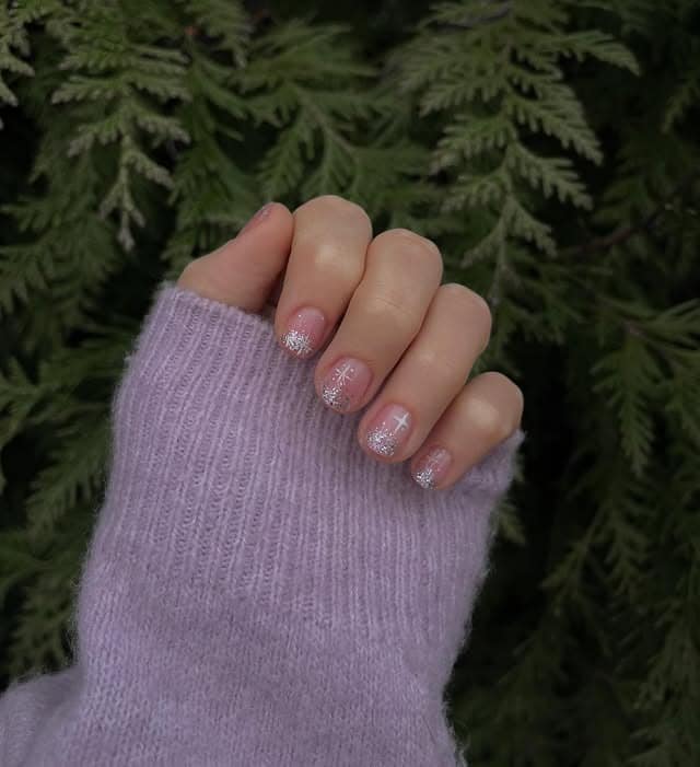 11. Sheer Pink Glitter Fade Short Nails with Snowflake Accents - short winter nail ideas