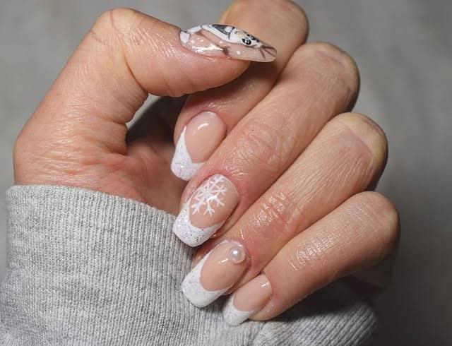 13. Classic Short French Nails with Snowflake and Pearl Detail - short winter nail ideas