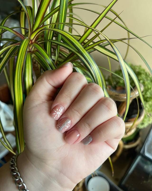 20. Soft Pink Glitter Accent Nails with Snowflake Detail - short winter nail ideas