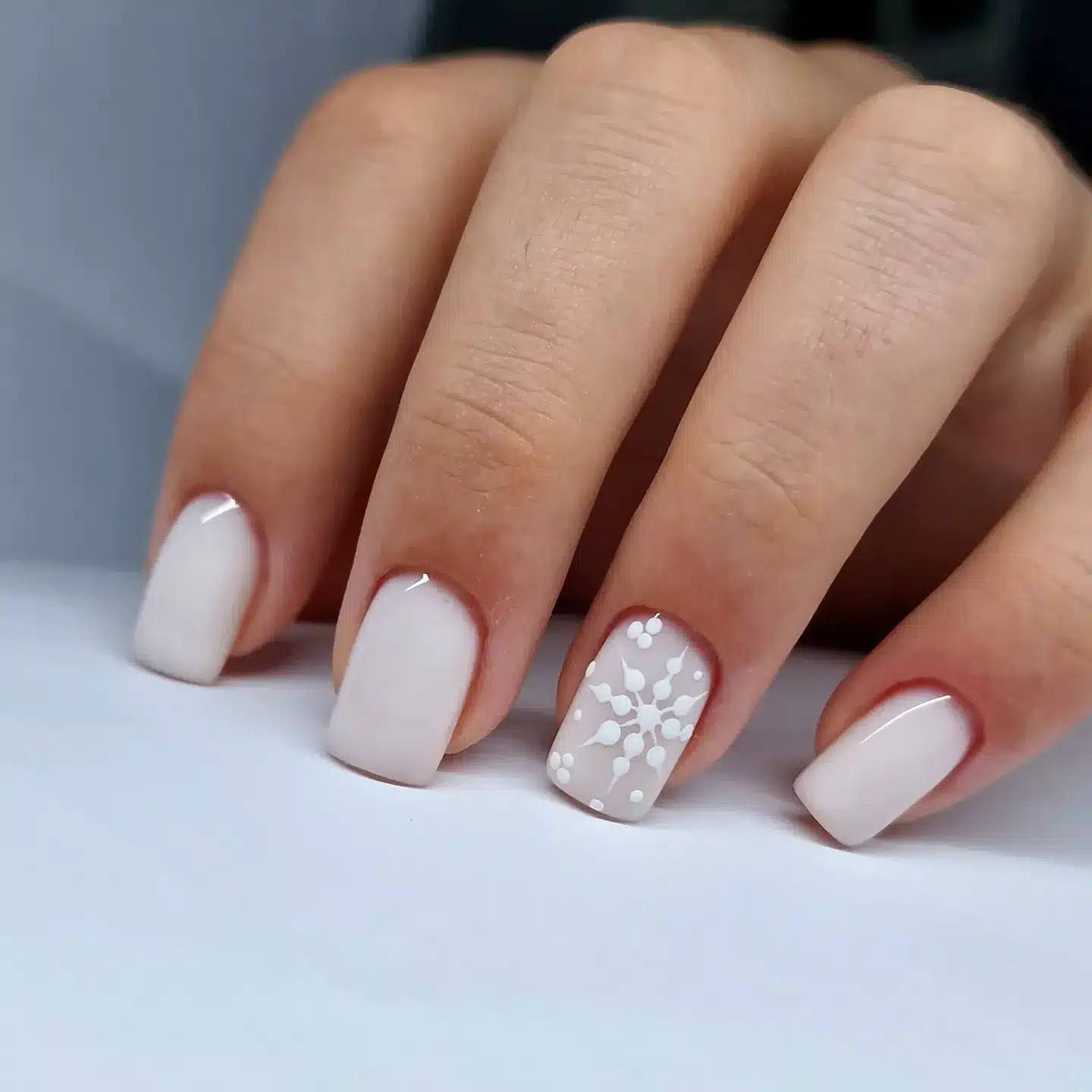 21. Minimalist Milky White Short Nails with Snowflake Accent - short winter nail ideas