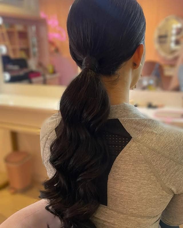 4. Soft Black Low Ponytail with Loose Waves - Sleek Low Ponytail