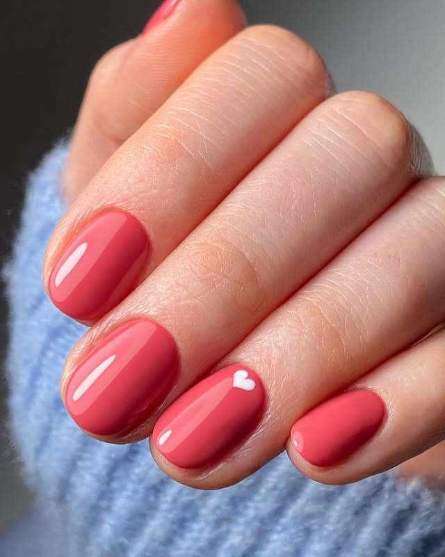 11. Glossy Coral Short Nails with Mini Heart Accent - short nail ideas