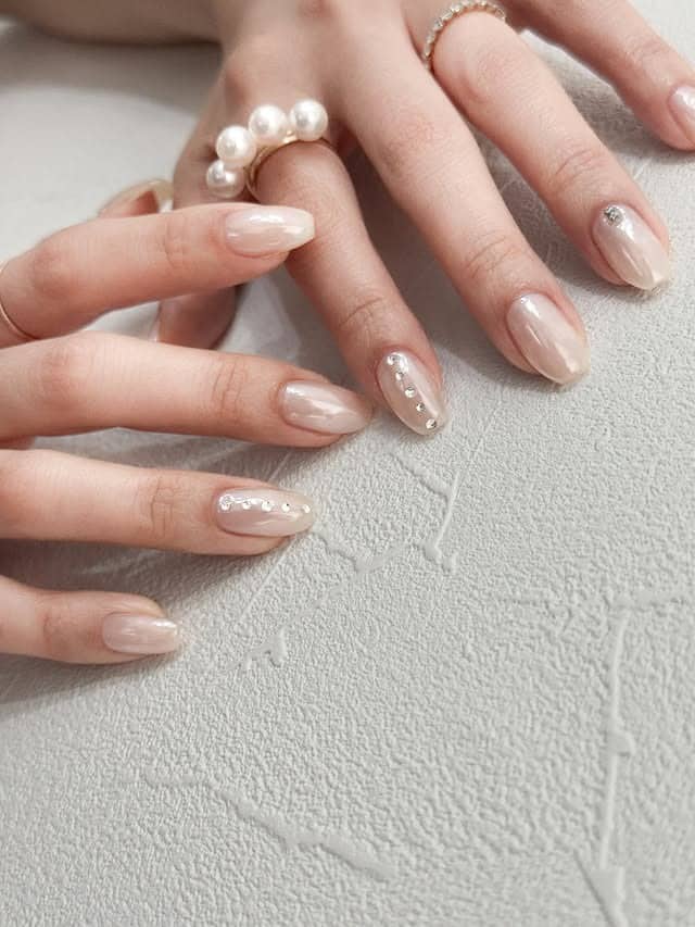 12. Pearl Nude Almond Nails with Crystal Accents - summer nail ideas