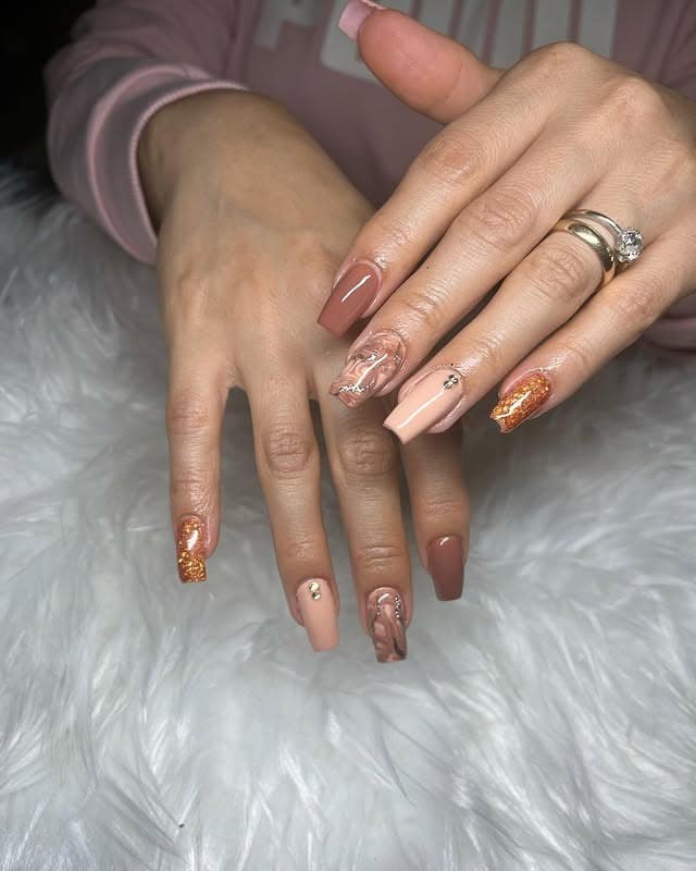 7. Neutral Glam Marble Coffin Nails with Gold Accents - small coffin nail ideas