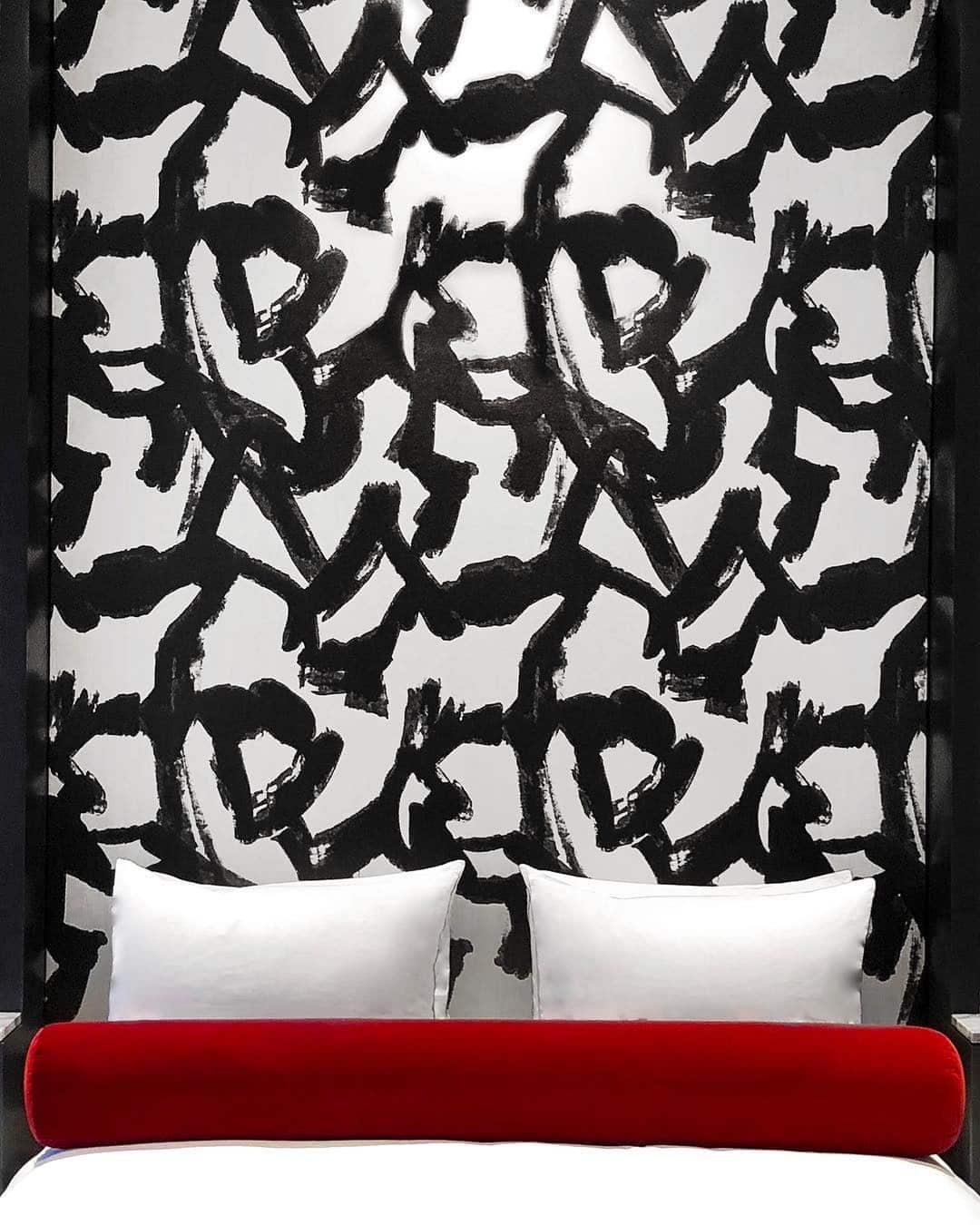 20. Artistic Black Brushstroke Wall with Red Bed Accent - red, black and white bedroom ideas