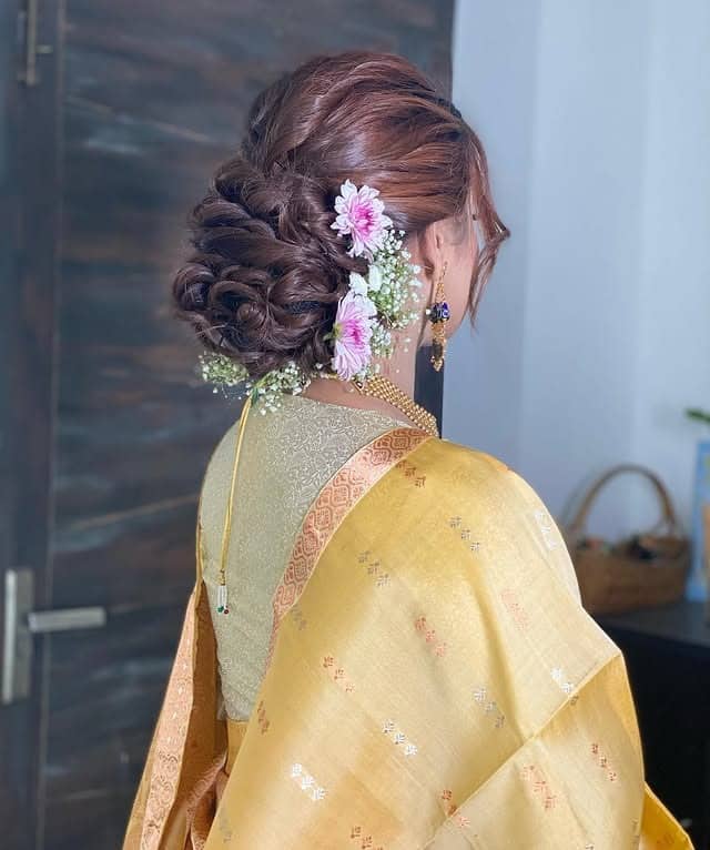 3. Romantic Chestnut Twisted Low Bun with Fresh Florals - Messy Bun Hairstyles