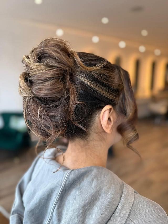 12. Dimensional Brunette Voluminous High Messy Bun - Messy Bun Hairstyles