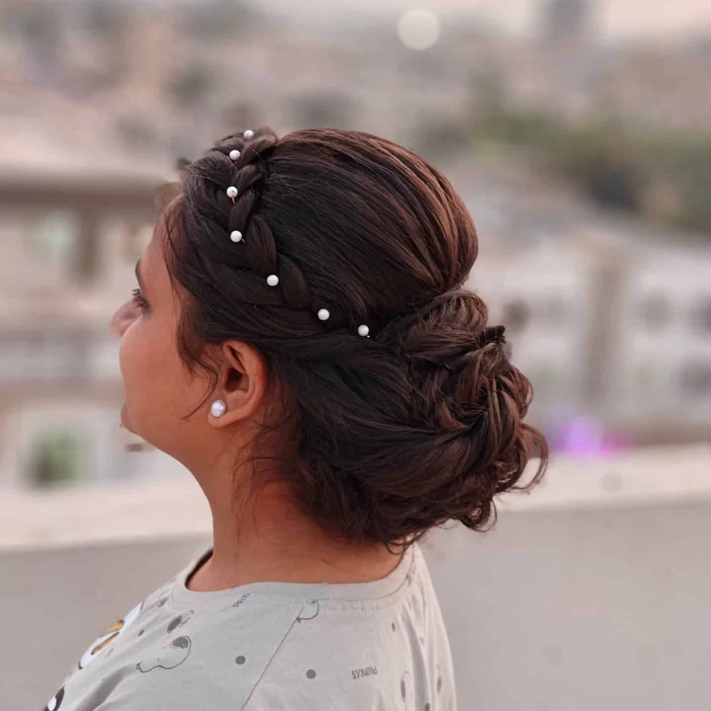 18. Warm Brunette Braided Messy Bun with Pearl Detail - Messy Bun Hairstyles