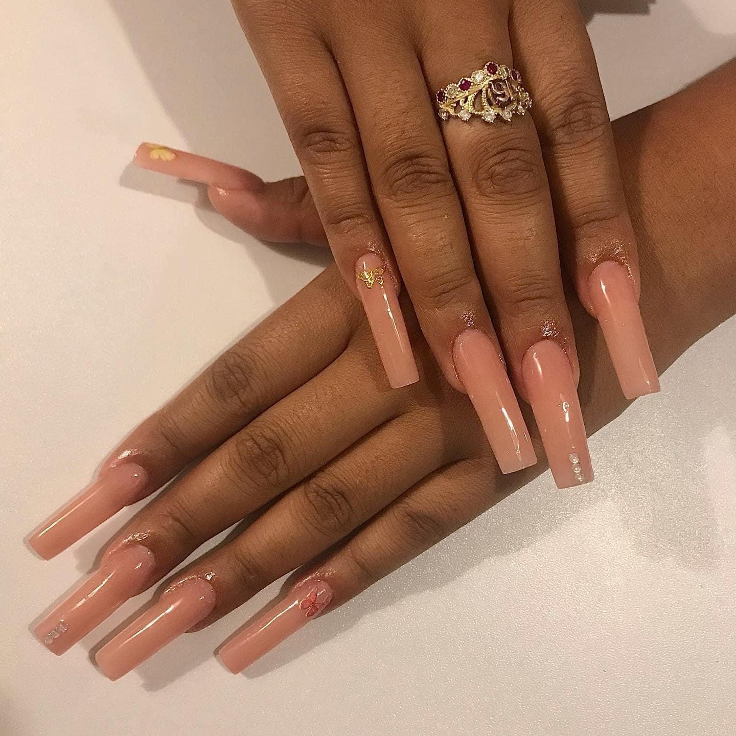 9. Glossy Nude Coffin Nails with Butterfly Accents - first day of school nail ideas