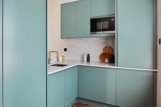 18. Dusty Blue Corner Kitchen With Marble Backsplash - corner kitchen ideas
