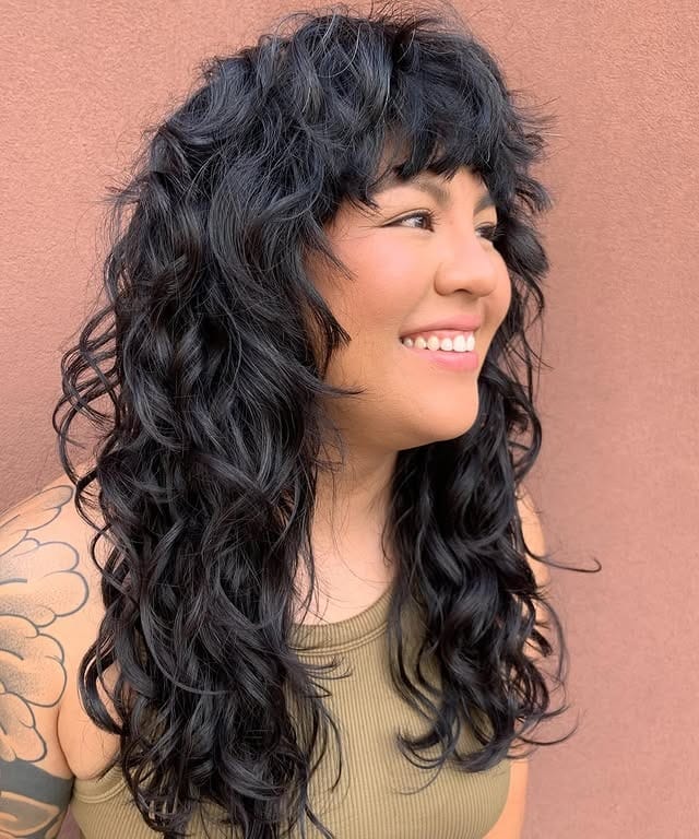 2. Shaggy Curly Wolf Cut with Soft Black Color - Wispy Bangs For Curly Hair